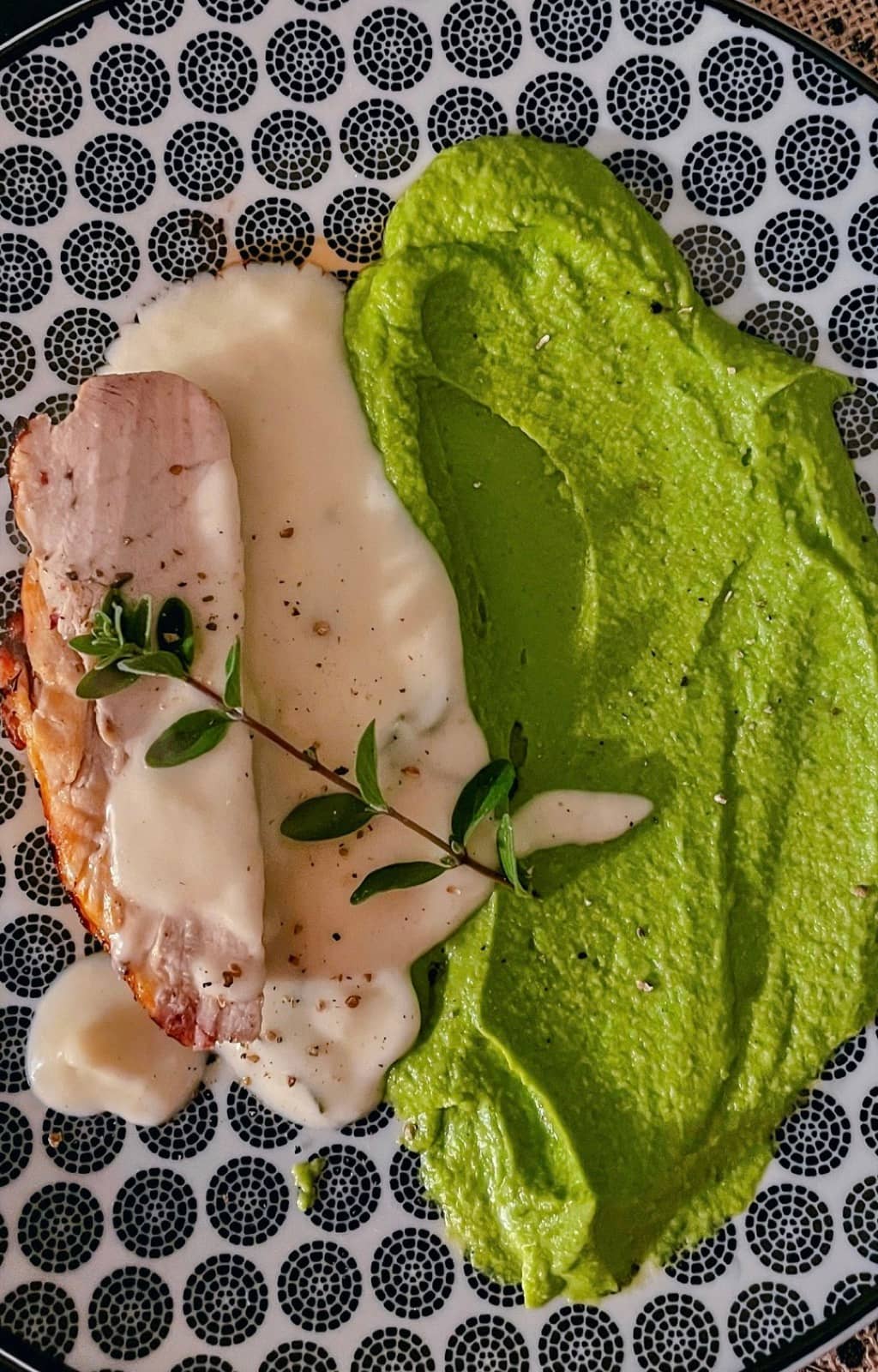 Roast chicken with pea and a white sauce, a sprig of thyme.